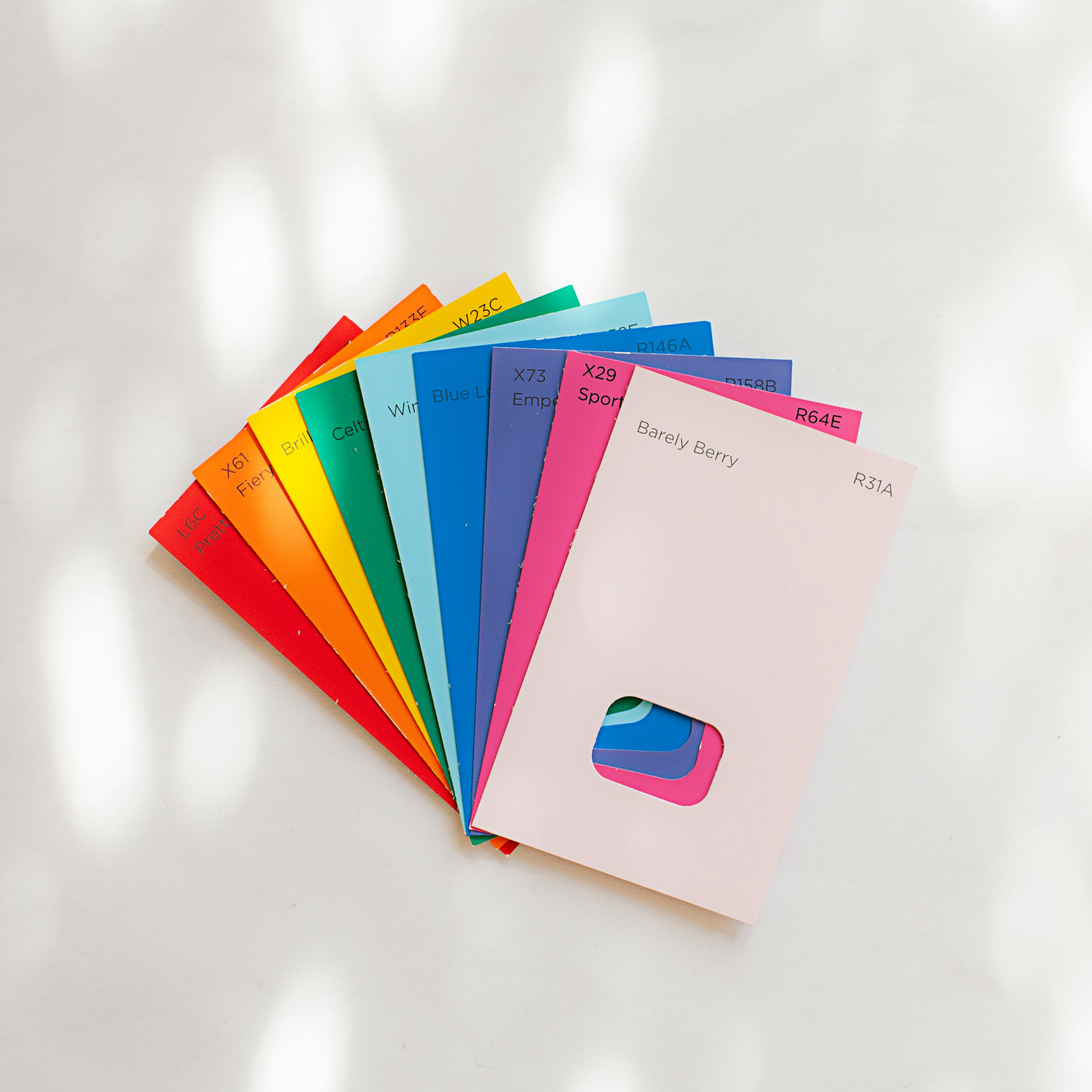 Photo of colourful paint swatch cards fanned out for comparison, used as a visual metaphor for evaluating and selecting the right MMM partner.