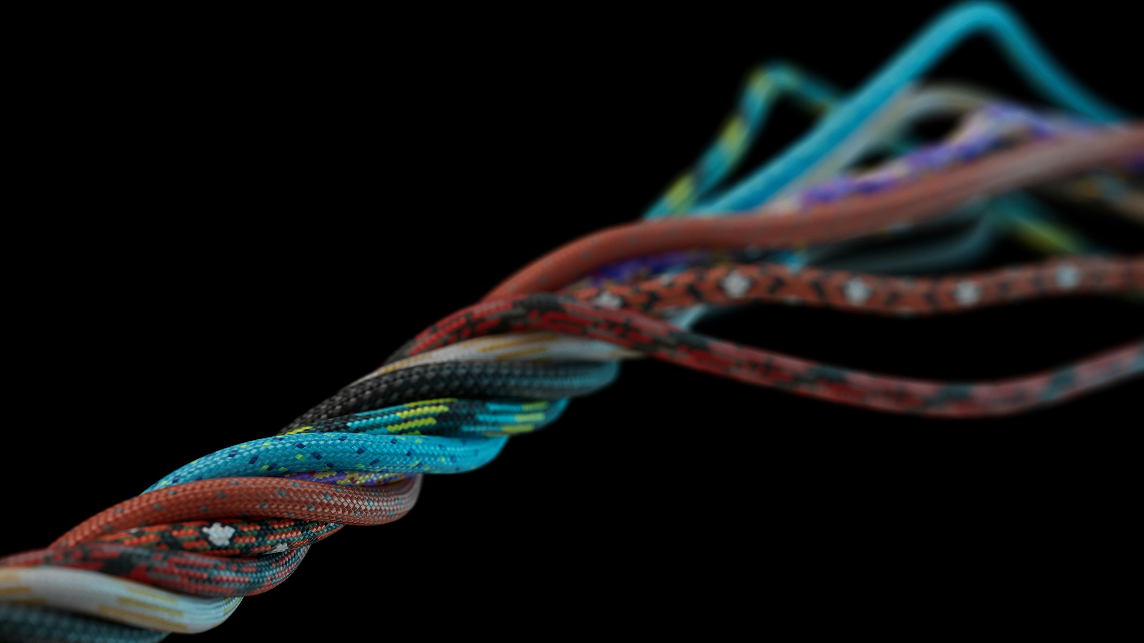 Photo of several colourful braided cables twisting together into a single cord against a black background, used as a visual metaphor for bringing scattered data and martech systems together into one coherent structure.